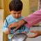 Sweet boy playing bells with spoon to in the Balcony during corona virus lockdown to give respect to doctors in IndiaÂ 